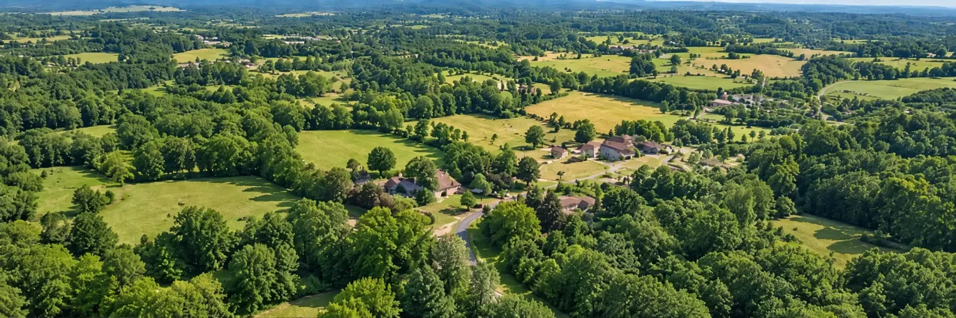 Illustration d’un paysage de campagne, entre champs, habitations et espaces boisés